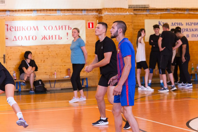 Игрок готовится к подаче на любительской тренировке по волейболу